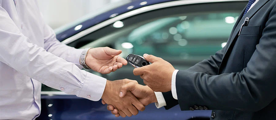 Bilhandlare säljer en ny bil till kund