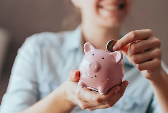 Glad kvinna sparar pengar i en spargris