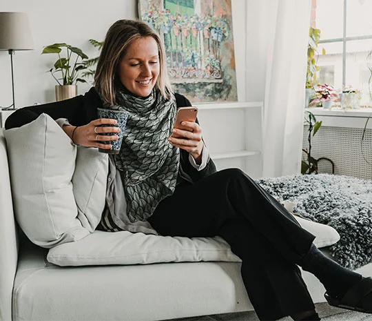 Kvinna jämför lån hemma i soffan