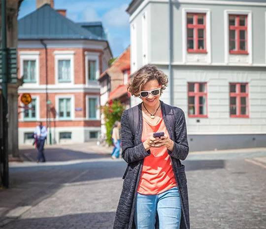 Kvinna på gata i Stockholm utforskar lån i mobilen