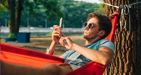 Man ligger i hängmatta och jämför lån