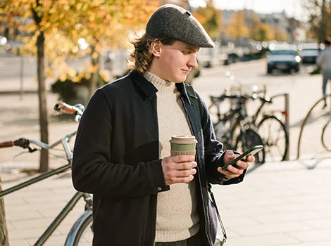 Man står på gata och jämför lån i mobilen