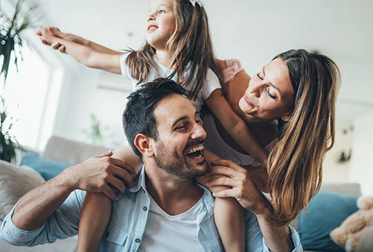 Familj med dotter som sträcker ut armarna