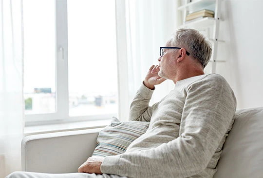 Man sitter i soffa och funderar