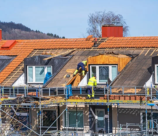 Snickare renoverar tak på hus